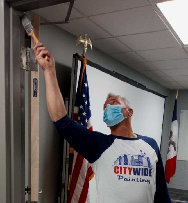 A painter painting the trim of a doorway