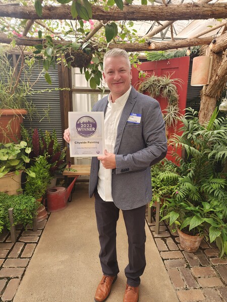 Brian, owner of Citywide Painting, posing with the best of 2023 reward.